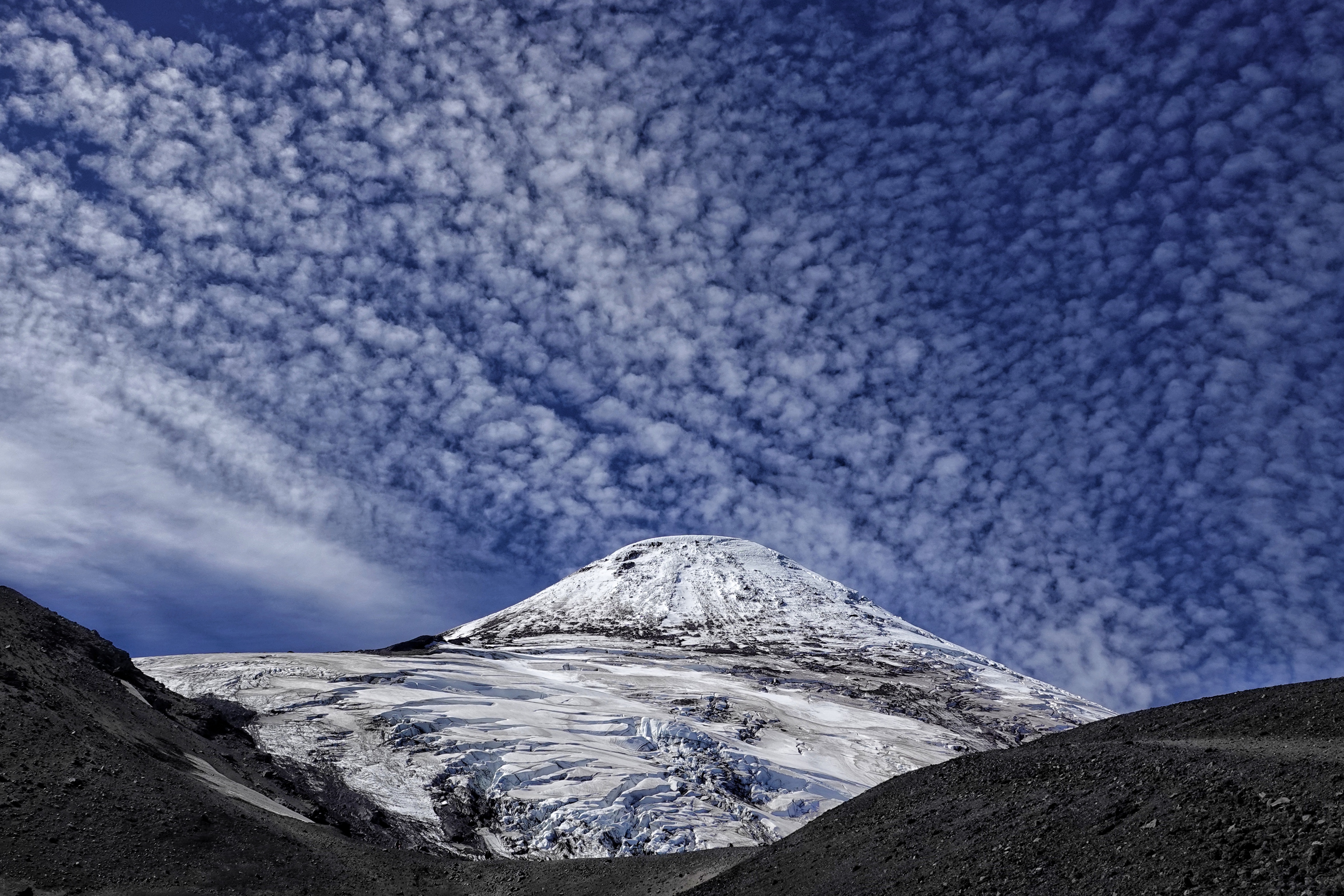 Volcan enneigé sous un ciel texturé